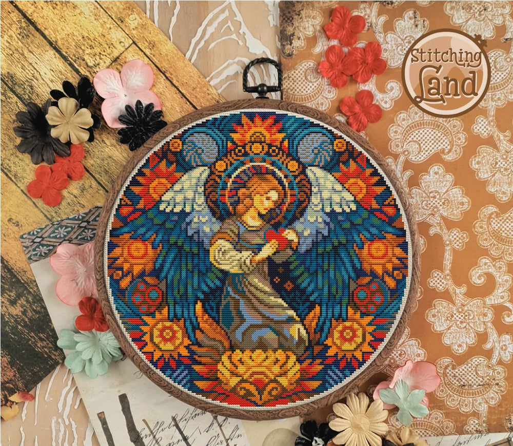 Stamped cross stitch design of an angel design in an embroidery hoop with decorative flowers on a textured background.