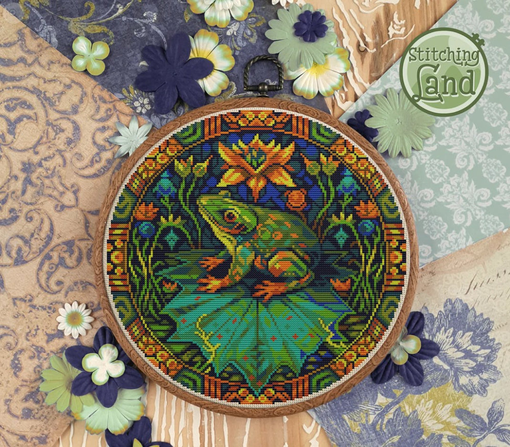 Stamped cross stitch design of a colorful frog design on a textured fabric background