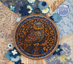Stamped cross stitch design of a owl design on a floral and paisley patterned fabric.