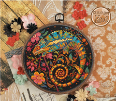Stamped cross stitch design of an Embroidery hoop with colorful chameleon design on a decorative background with flowers.