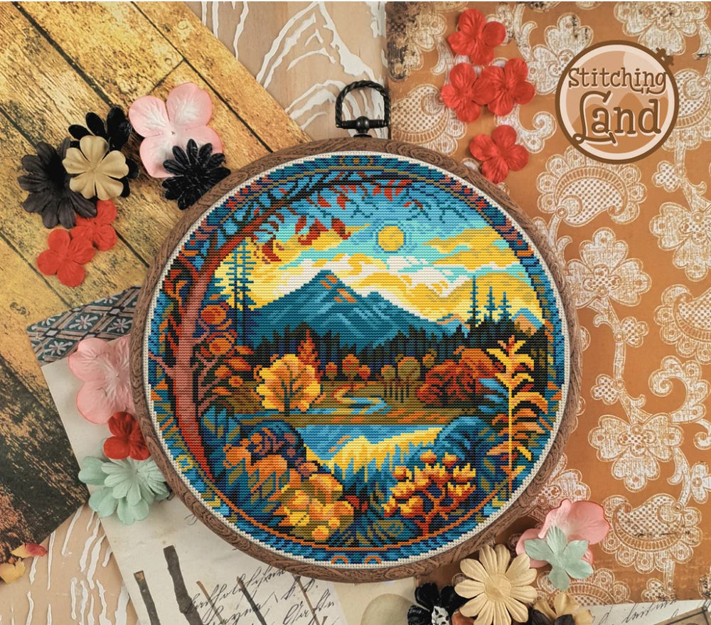 Stamped cross stitch design of a scenic design surrounded by decorative flowers on a textured background.