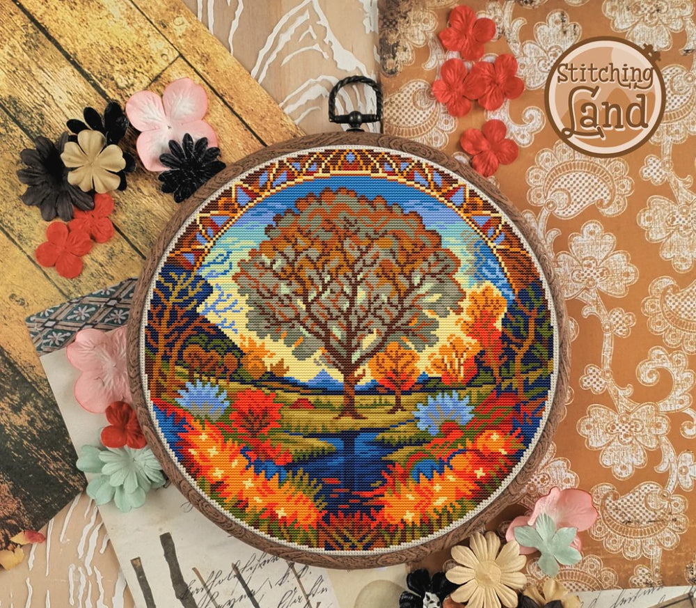Stamped cross stitch design of a colorful landscape design on a decorative background with flowers and lace.