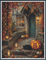 Framed cross stitch mock-up of Autumn at Owl Cottage by Ricco, available from The Stamped Stitch Club. A cosy stone cottage with a teal front door, glowing lanterns and rich autumn foliage. A black cat rests beside a carved owl pumpkin, surrounded by fallen leaves, smaller pumpkins and baskets on the cottage steps.