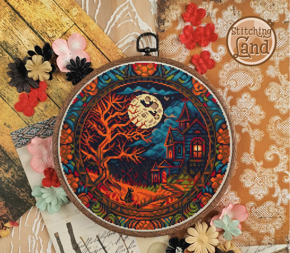 Stamped cross stitch design of a colorful moonlit scene design on a textured surface with flowers.