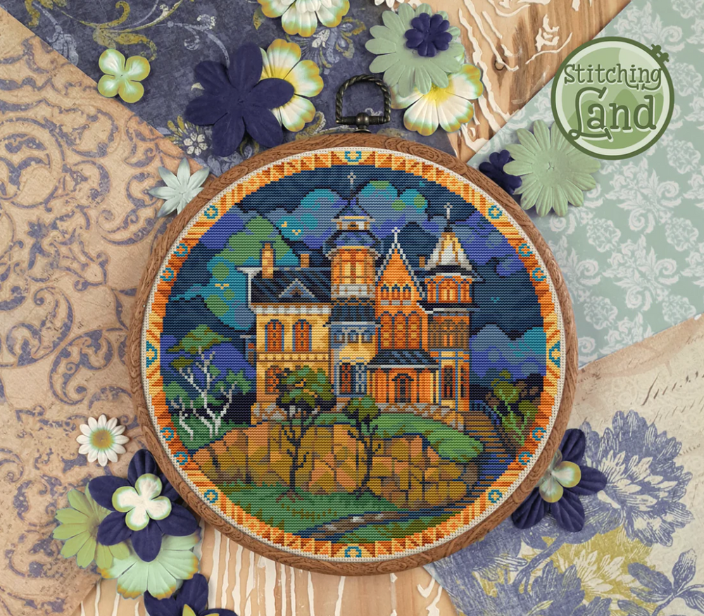 Stamped cross stitch mockup of a castle in an embroidery hoop with decorative flowers and fabric background.