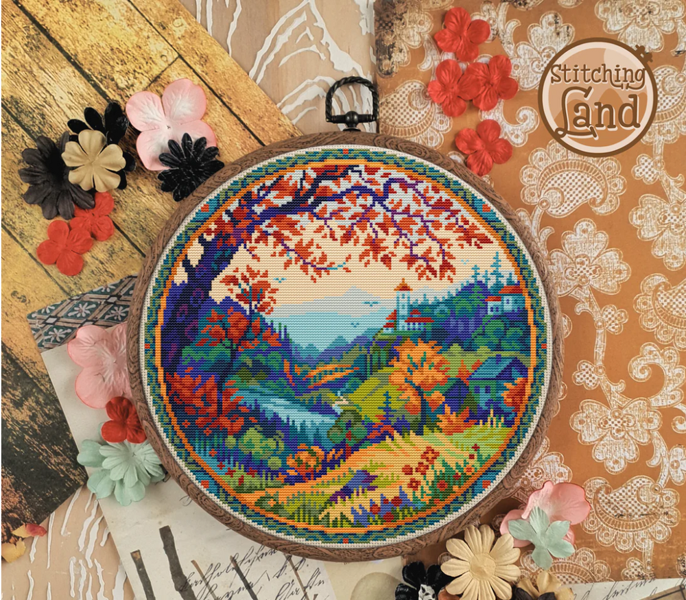 Stamped cross stitch mockup of a landscape in an embroidery hoop with decorative flowers on a textured background