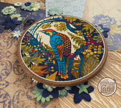 Embroidery hoop with a colorful peacock design on a floral background, featuring the brand 'Stitching Land'.