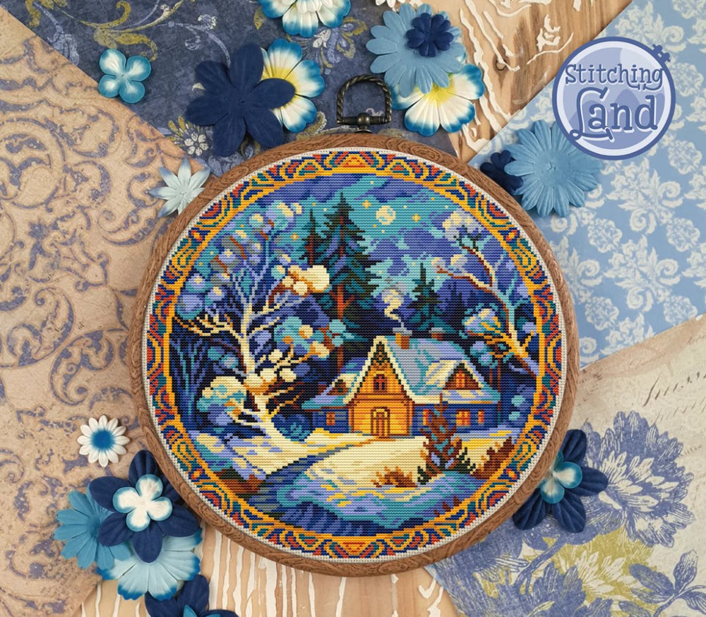 Stamped cross stitch design of a snowy landscape with a cabin, surrounded by decorative flowers and 'Stitching Land' branding.