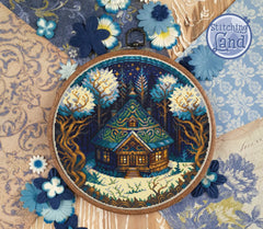 Stamped cross stitch design of a cabin in a snow laden winter forest