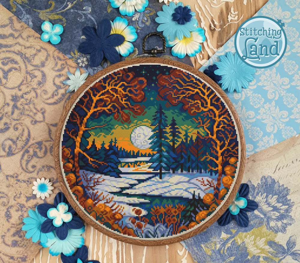 Stamped cross stitch design of a forest and river in winter