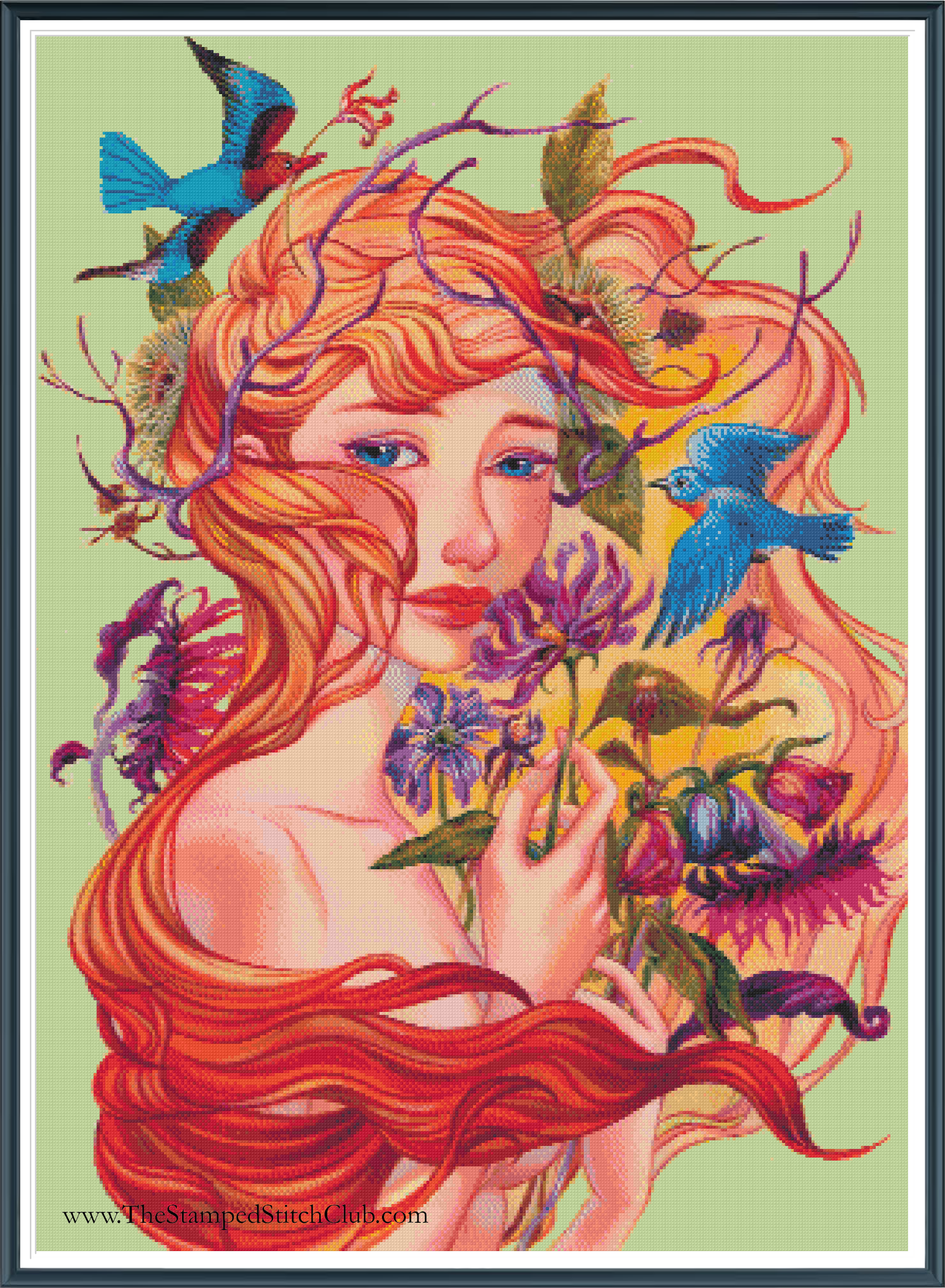 Framed cross stitch mock-up of Autumn by Maria Abignale, available from The Stamped Stitch Club. A beautiful fantasy portrait of a woman with flowing copper-red hair, surrounded by vibrant autumn flowers, purple foliage and vivid blue birds against a soft green background.