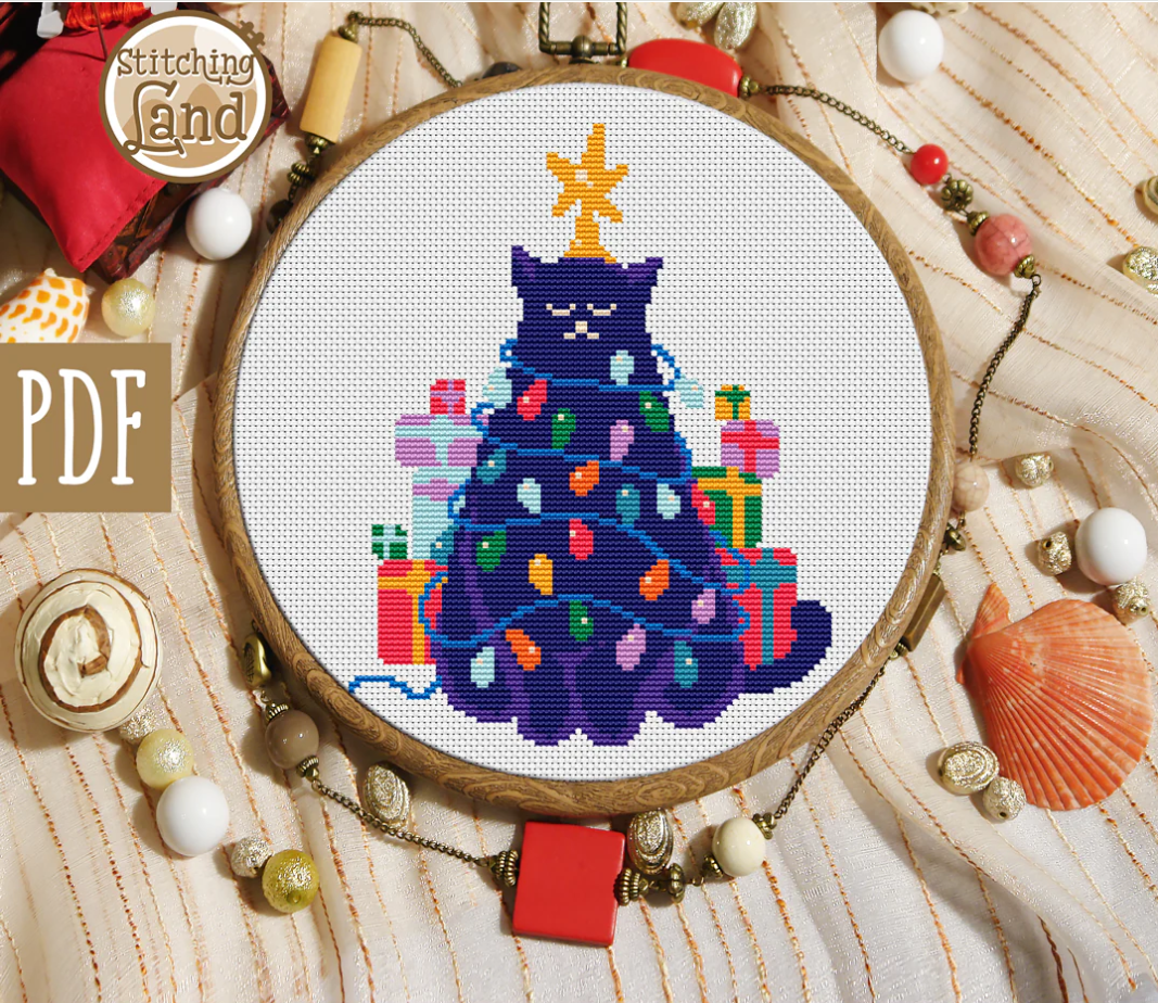 Stamped cross stitch mockup of a  cat decorated like a Christmas tree with presents on a fabric background.