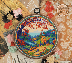 Stamped cross stitch mockup of a  landscape in an embroidery hoop with decorative flowers on a textured background